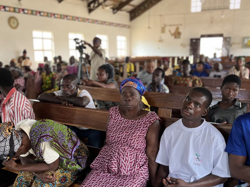 Beneficiaries and community members seated in the church hall during the launch